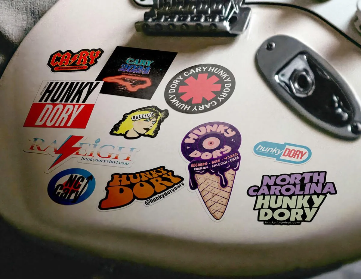 Hunky Dory stickers that riff on classic band logos, stuck to a guitar body