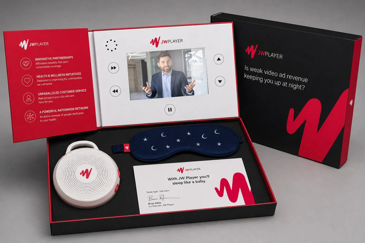 The JW Player mailer open: a video screen playing the pitch, a white-noise machine, a sleep mask, a signed note and a lid asking Is weak video ad revenue keeping you up at night?