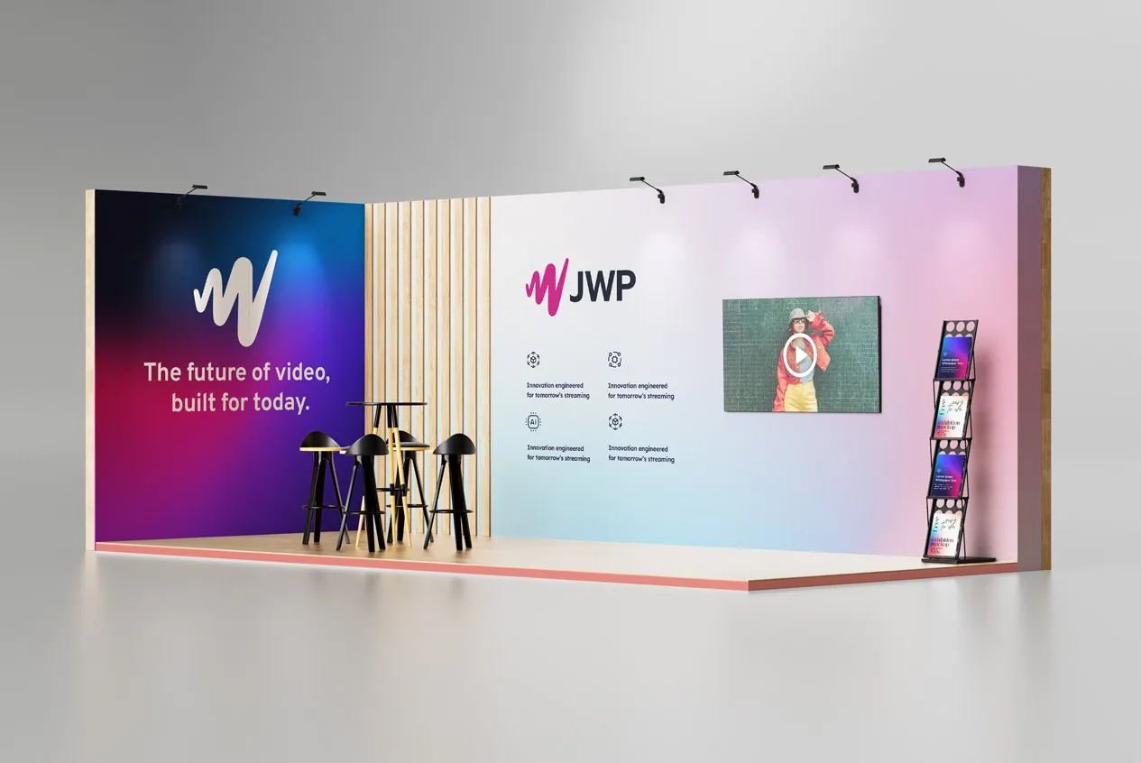 A JWP trade show booth: the W on a deep gradient wall reading The future of video, built for today, beside a light wall with the JWP logo and a video screen