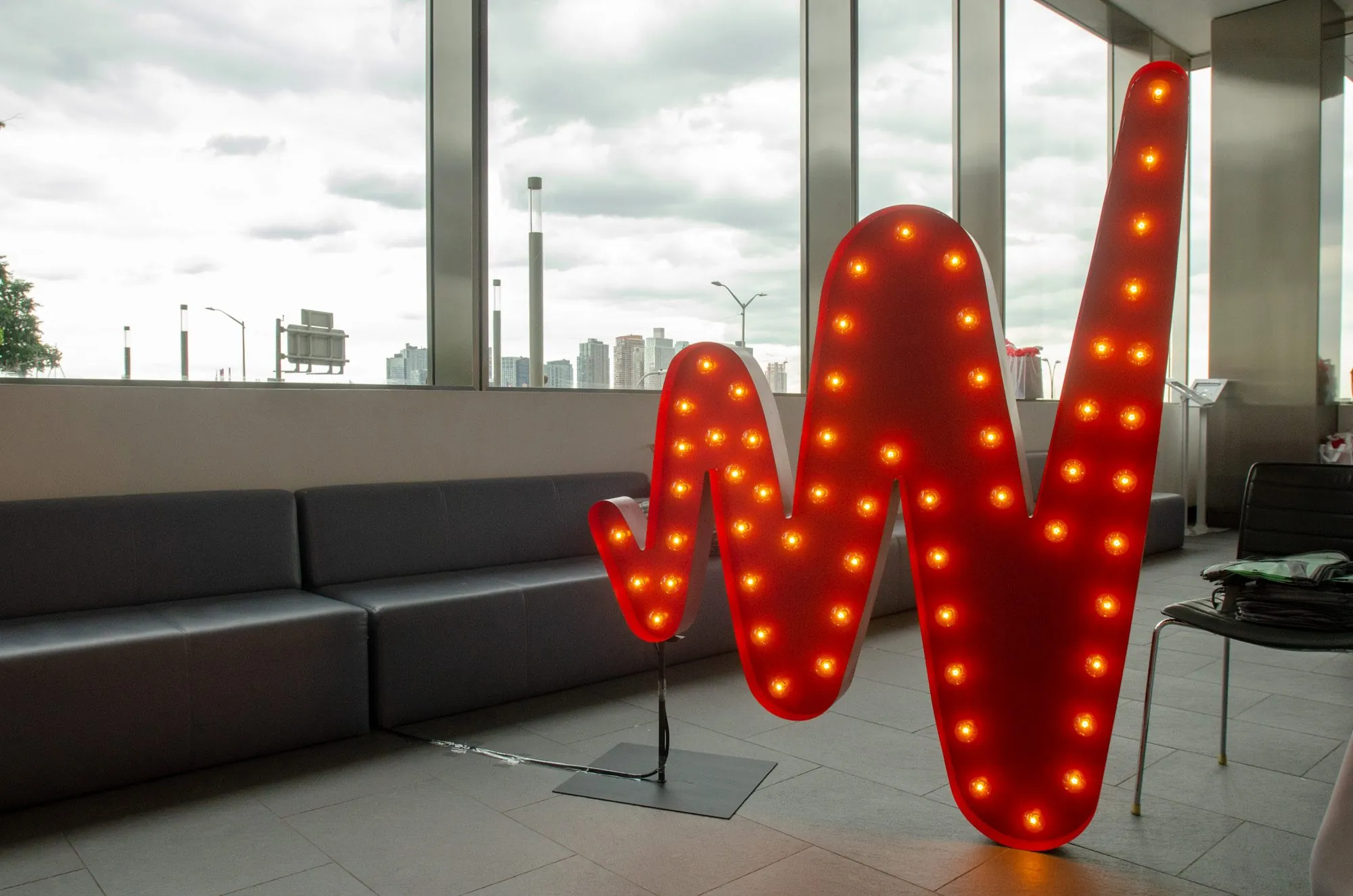 A giant marquee W lit with bulbs in a lobby overlooking the city