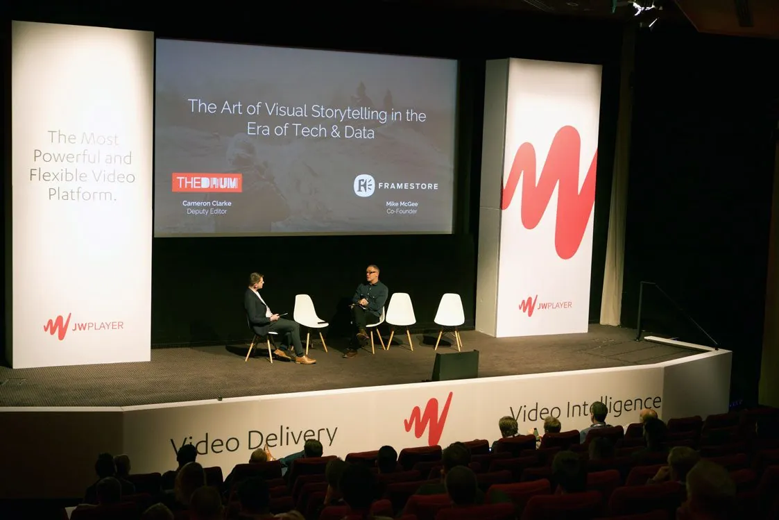 The Insights London main stage: a panel on The Art of Visual Storytelling, framed by white JW Player pillars and a riser reading Video Delivery and Video Intelligence
