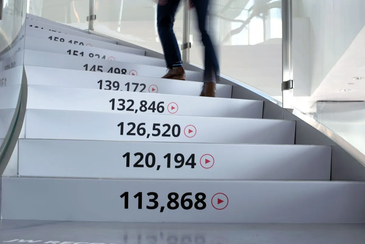 A guest climbing stairs whose risers count up the videos streamed through JW Player, each number with a red play button